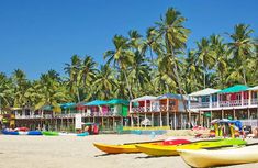 colorful beach houses line the shoreline with canoes and kayaks lined up on the sand