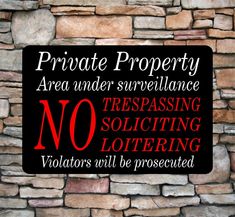 a sign that says private property area under surveillance no trespassing solicing loitering violators will be protected