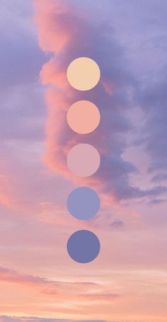 the sky is filled with clouds and five circles are arranged in different colors on each side