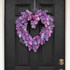 a heart shaped wreath is hanging on the front door to give it a touch of color