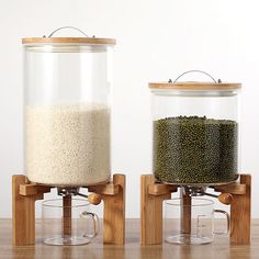 two glass containers filled with food sitting on top of a wooden stand next to each other