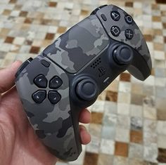 a person holding a video game controller in their hand on a tiled floor with tiles