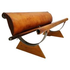 a wooden bench with metal legs and a leather case on it's back end