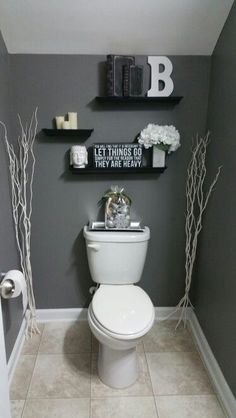 a white toilet sitting in a bathroom next to two black shelves