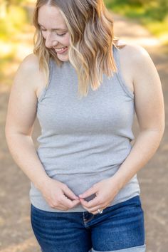 Elevate your style with the Tara Ribbed Tank in sophisticated grey! This tank combines fun and fashion with its micro ribbed texture and high neckline. Perfect for any occasion, it offers a comfortable fit that you'll love. Fabric Composition: 93% rayon, 7% spandex for a soft and stretchy feel.Fit: True to size.Model Sizing: Catherine and Tiffanee are wearing a small, and Lexi is in a 1XL. Upgrade your wardrobe with the Tara Ribbed Tank, a must-have versatile piece. Gray Ribbed Tank Top For Spring, Gray Stretch Tank Top For Fall, Bath And Body Shop, Fall Graphic, Kimono Duster, Kids Graphic Tees, Leggings Kids, Winter Kids, Ribbed Texture