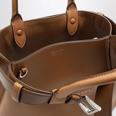 Caramel-coloured leather Prada medium bag featuring a decorative buckle belt, two top handles with strap detail, adjustable and removable shoulder strap, two internal compartments and contrasting front lettering logo. Width 33 cm x Height 22 cm x Depth 12 cm Adjustable shoulder strap length min 90 cm - max 100 cm Handle drop: 13 cm Size Type: INTMaterial: LeatherSKU: 1BA434OBO2CY9/O_PRADA-F03BH_100 Our Products Are 100% Genuine. In All Cases We Stand By The Authenticity Of Every Product Sold On Balenciaga Backpack, Buckle Bag, Buckle Bags, Belt Women, Medium Bag, Lettering Logo, Bottega Veneta Shoulder Bag, Caramel Color, Louis Vuitton Shoulder Bag