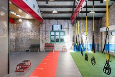 an indoor gym with swings and exercise mats