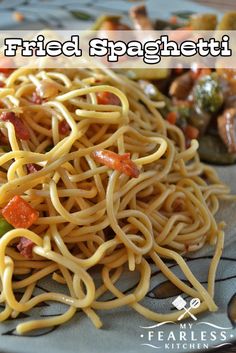 a plate of noodles with sauce and vegetables on the side text reads fried spaghetti recipe