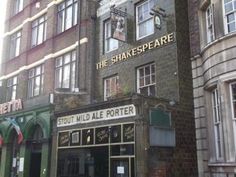 the shakespeare is located in an old brick building with many windows and signs on it