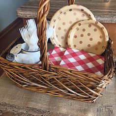 a wicker basket with plates and utensils in it