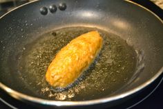 a fried piece of food in a frying pan on top of a stovetop