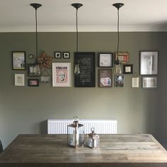 a wooden table sitting in front of a wall with pictures on it's side