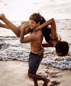 a man and woman are playing on the beach