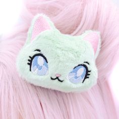 a close up of a cat hair clip on top of a pink furry material head