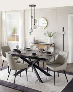 a dining room table with chairs around it and a rug in front of the table