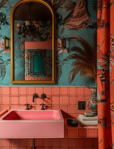 a pink sink sitting under a mirror in a bathroom