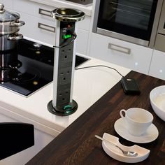 a stove top oven sitting inside of a kitchen next to a cup and saucer