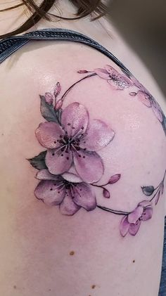 a woman's shoulder with pink flowers on it