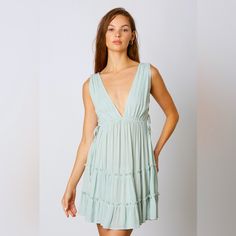 This Deep V Swing Dress Showcases An Alluring Silhouette With Beautiful Ruffle And Lace Up Side Cut Out Details. Perfect For A Beach Or Boho Look, This Dress Will Make You Stand Out In Any Occasion. Color: Mint Self 100% Rayon Breezy V-neck Beach Cover-up Dress, Summer V-neck Beachy Mini Dress, Breezy V-neck Mini Dress For Vacation, Breezy Mini Dress For Beach Cover-up, Flowy V-neck Sundress For Beach Party, Breezy V-neck Beach Party Dress, Breezy V-neck Mini Dress For Day Out, Beachy Flowy V-neck Mini Dress, Beachy V-neck Flowy Mini Dress