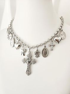 Religious Saints Necklace - Medals and Crosses in Stainless Steel Catholic Medals Necklace Gift for her, Catholic Christmas Gift, Multi charms necklace This stunning Catholic Saints Necklace is designed for those looking for a unique and meaningful accessory. Made from high quality stainless steel, this necklace is a durable piece that is resistant to daily wear and tear, ideal for expressing your faith in style. The necklace features a Sacred Heart cross in the center, surrounded by multiple me Silver Necklaces With Dangling Charms For Gift, Silver Symbolic Necklaces With Dangling Charms, Silver Necklaces With Dangling Charms, Silver Cross Necklace With Charms, Handmade Silver Necklace For Christmas, Silver Spiritual Necklace With Vintage Charm, Spiritual Silver Necklace With Vintage Charm, Catholic Christmas Gifts, Guadalupe Necklace