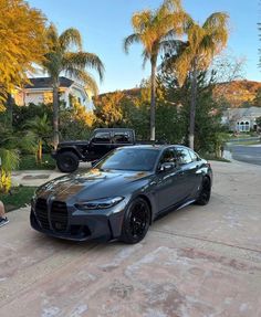 a black sports car parked in front of some palm trees