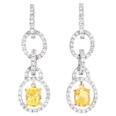 Shine with these Designer Leo Pizzo Natural fancy yellow Diamond Dangel earrings are crafted in Platinum and 18k yellow gold details. They are centered with 2 genuine oval cut fancy yellow Diamonds approx: 1.50 carats in total, Natural Fancy intense Yellow,  VS1 clarity, prong set in yellow gold, and adorned with approx 140 genuine round cut Diamonds approx: 1.00 carats, F-G color color, VS  clarity, prong set. These beautiful dangle earrings feature a bright polished finish for extra shine and Fancy Yellow Diamond, Oval Diamond, Yellow Diamond, Gold Details, Round Cut Diamond, Prong Setting, Ear Piercings, Platinum, Jewelry Earrings Dangle