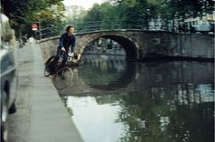 a man riding a bike across a bridge over water