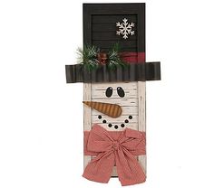 a snowman made out of an old door with a bow on it's head