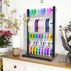 a bunch of different colored ribbons are on a table next to flowers and vases