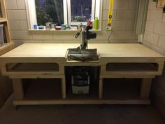 a workbench made out of wood with a sink and window in the background