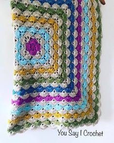 a crocheted blanket hanging from a hook