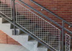 there is a metal handrail on the stairs next to a brick wall and door