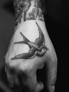 a hand with a bird tattoo on it