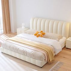 a white bed sitting on top of a hard wood floor