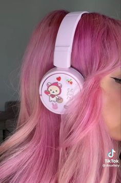 a woman with pink hair wearing headphones