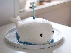 a cake shaped like a whale on top of a white plate with blue sprinkles