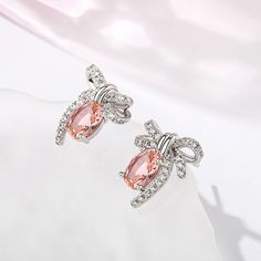 Romantic, enchanting and compassionate, the gentle pink blush of morganite creates a sense of calm and reflects the happier aspects of life. Inspired by vintage designs, these lovely earrings are crafted in sterling silver and showcase a beautiful bow with diamonds for a touch of sparkle. A wonderful gift or well earned treat for yourself.Carat Weight: 2.3 ctStone Size: 6*8 mmNumber of Stones: 2 Stone Shape: OvalStone Color: Fancy PinkCarat Weight: 0.934 ctStone Size: 1.3,1.1 mmStone Type: Jeuli Elegant Blush Earrings, Feminine Pink Earrings For Anniversary, Pink Sterling Silver Earrings Perfect For Her, Pink Sterling Silver Earrings For Her, Pink Sterling Silver Earrings As Gift For Her, Pink Round Earrings Gift For Her, Pink Round Crystal Earrings For Formal Occasions, Blush Drop Earrings For Gift, Elegant Oval Peach Jewelry