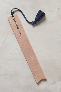 a bookmark with a tassel attached to it sitting on a white table top