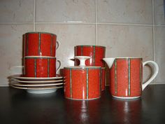 four red and white cups sitting on top of a table next to eachother