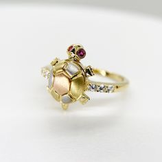 14k Solid Gold Turtle Tourmaline Tri Color Red Eye Moving Head Lucky CZ Ring for Women Girl * Metal : Real 14K Yellow Gold * Condition : Brand New * Finish : Polished * Height : 14.6 mm * Weight : 2.9 gram This is an approximate size & weight. Please expect up to ±10% difference. * Processing time : 1~2 business days * Ships from California This is 100% Authentic 14k Gold. Not plated or filled. All of our items are brand new and are shipped with a gift box. Tortoise Gold Ring Design For Women, Gold Ruby Ring With Cubic Zirconia For Gift, Gold Ruby Ring With Accent Stones As Gift, Gold Ruby Ring With Accent Stones In Sterling Silver, Yellow Gold Ruby Ring With 17 Jewels For Gift, Gold Multi-stone Ruby Promise Ring, Gift Red Multi-stone Diamond Ring, Tortoise Ring For Women Silver, Gift Multi-stone Red Diamond Ring