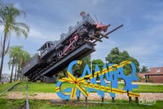 a train is going down the tracks in front of a sign