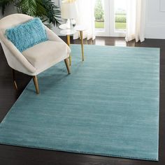 a living room with a blue rug and white chair