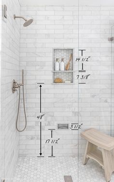 a bathroom with a bench, shower head and shelving on the wall next to it