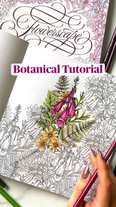 a woman's hand holding a pencil over a coloring book with flowers on it