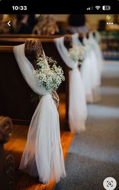 flowers are tied to the pews at a wedding