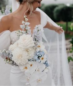 a woman in a wedding dress holding a bouquet of flowers