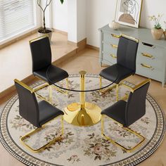 a round table with four chairs and a rug in front of it on top of a hard wood floor