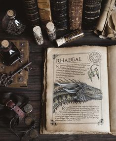 an open book sitting on top of a wooden table next to books and other items