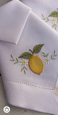 two white sheets with embroidered lemons on them