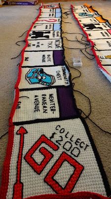 a long row of knitted signs sitting on top of a carpeted floor next to a tv